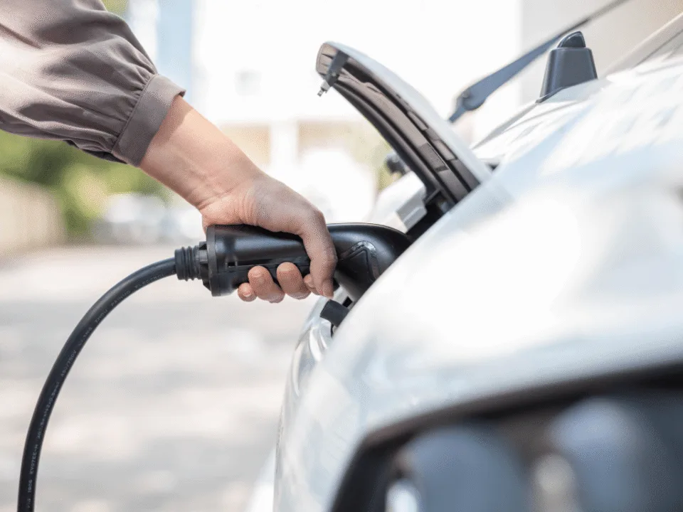 Driver connecting an EV charging cable to a car