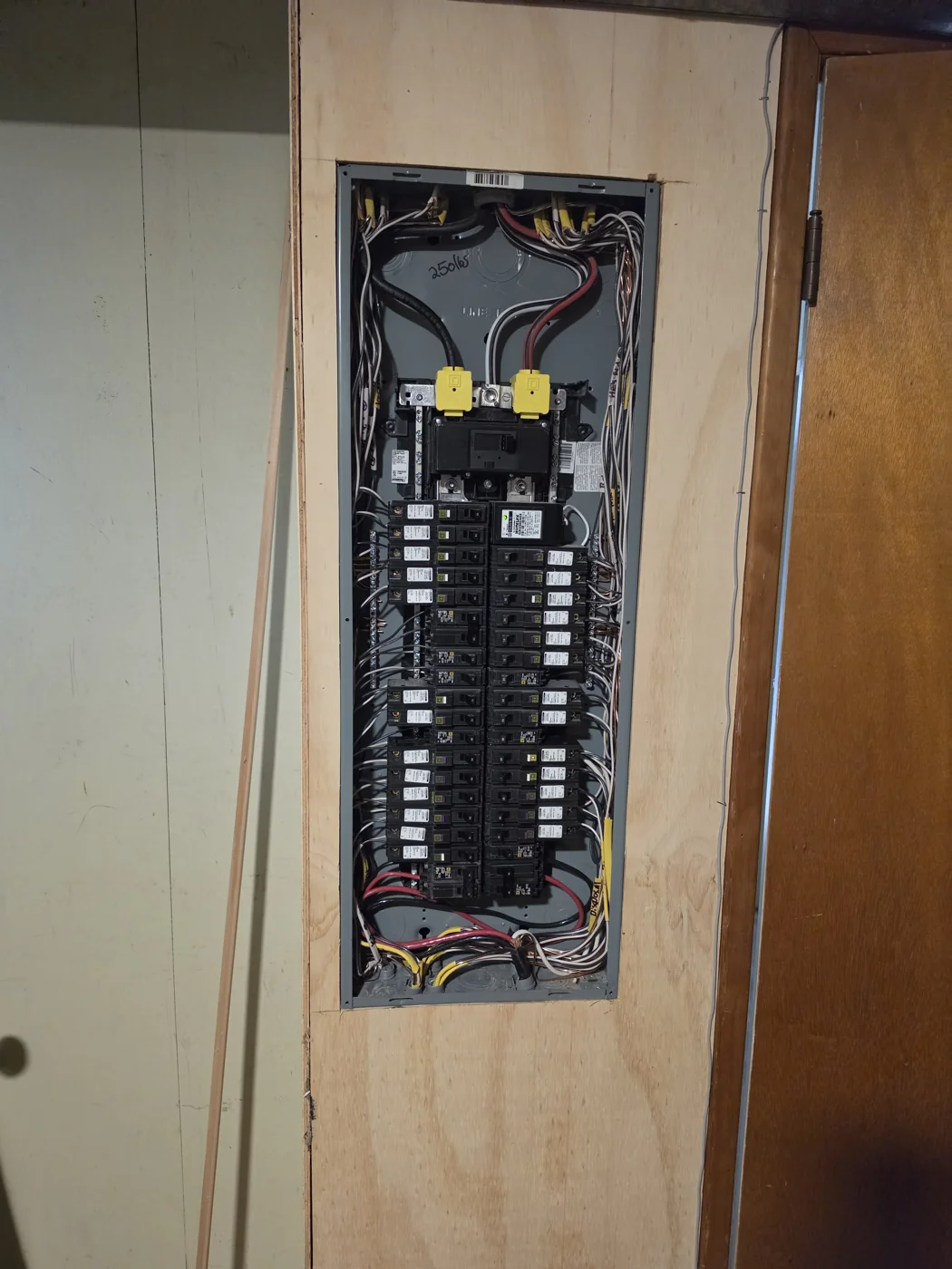 Open residential electrical panel showing breakers and branch-circuit wiring