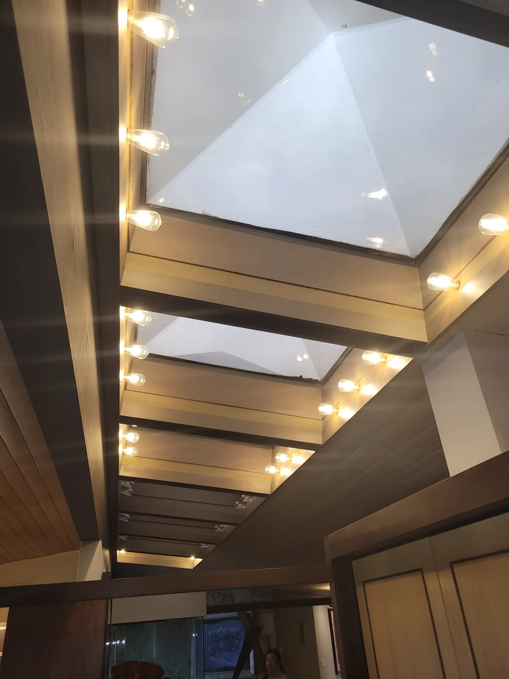 Recessed ceiling lights alongside skylights and exposed beams